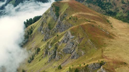 High Mountain Cliffs with Autumn Meadows Surrounded By Mist