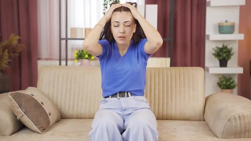 Pensive Woman Sitting on a Sofa