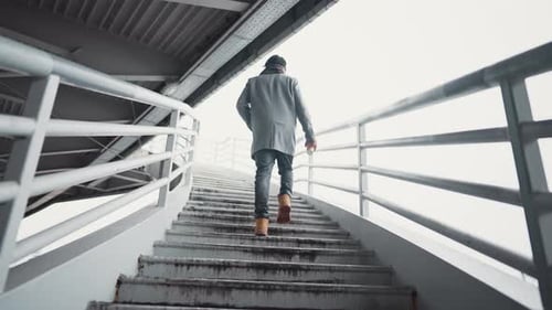 Lonely Male Person Walking in Urbanscape Back View of Man Moving Up on Stairs Slow Motion Shot