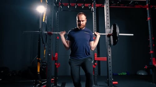 young motivated bodybuilder squatting with heavy barbell in gym exercise active lifestyle body care