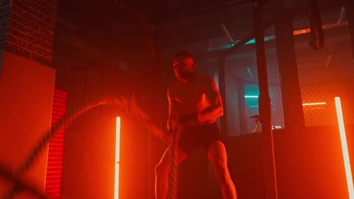 Muscular Man Doing Battle Rope Workout in Gym