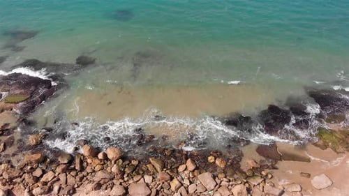 Aerial Dolly shot of Waves hitting the shore in Mediterranean sea