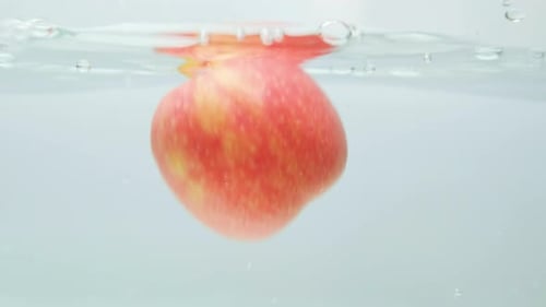 Roter Apfel fällt ins Wasser