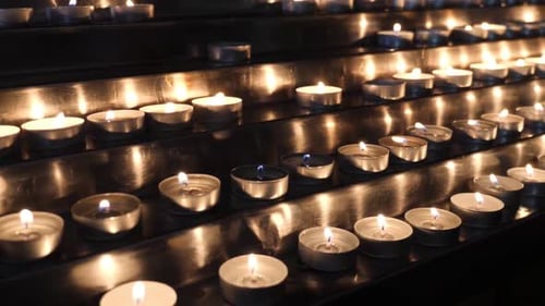 Burning candles on a multi-tiered stand in the church.