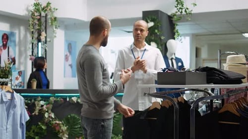 Mall Employee Assisting Customer to Choose From the New Collection of Clothes