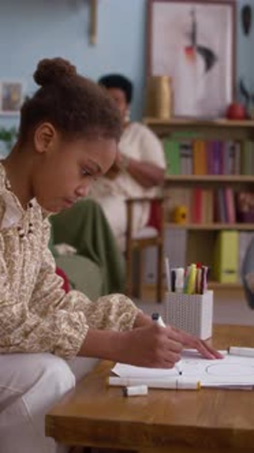 Girl Drawing at Table at Home