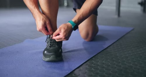 Fitness, man and shoe lace for sport training, workout or exercise on a mat at the gym indoors