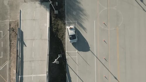 Aerial view of a car parallel parking in a driving test center. Vehicle driving training school.
