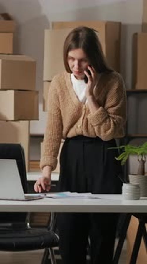 Woman Talking on Phone While Working on Laptop