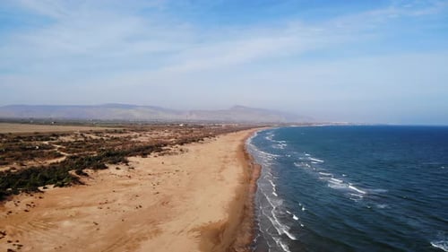 Scenic Coastal Landscape With Dunes Serene Seaside Scene Featuring Ocean Waves And Distant Peaks