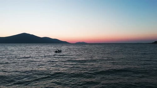 Albanian Adriatic sea coast with empty boat floating, colorful golden hour