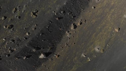 birdseye view of the ground with rocks and black sand drone shot in iceland