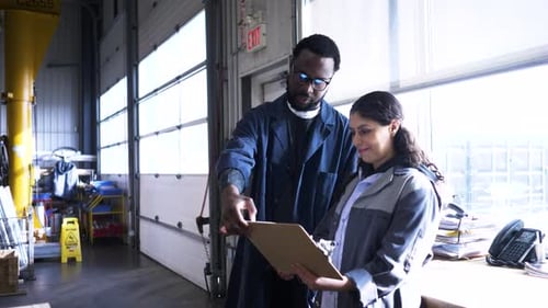 Workers with Board Meeting in Manufacturing Plant
