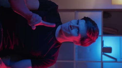 Man Pointing Finger at Camera in Dimly Lit Room