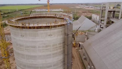 Amplio sitio de construcción de silos al amanecer: vista aérea revelada