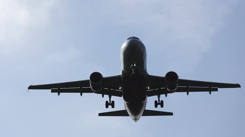 passenger airplane flies overhead, lands at the airport