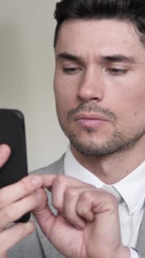Man in Suit Using Smartphone