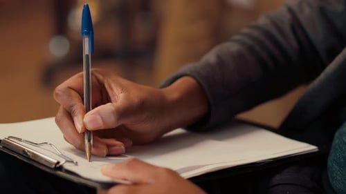 Un psychologue de sexe masculin rédige des notes lors d'une consultation