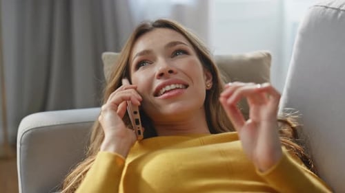 Woman Talking on Cell Phone While Lying on Couch