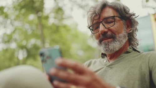 Man Uses Cell Phone Outside on a Sunny Day