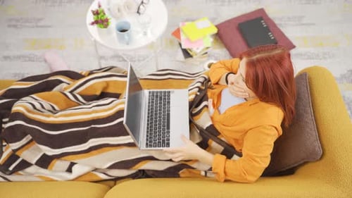 Woman Works on Laptop, Lying on Couch