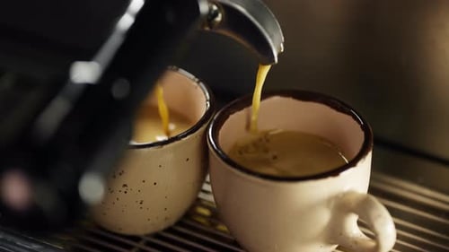 Slow Motion Video of Espresso Pouring Into a Cup From a Coffee Machine