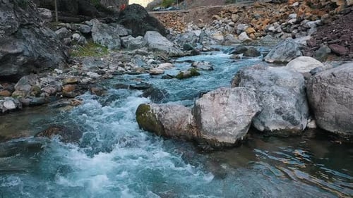 Mountain River Water Flows Down the Stones Turning Into a Stream