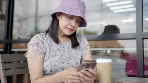 Middle-aged woman drinking coffee using smartphone in coffee shop Happy smiling professional woman a