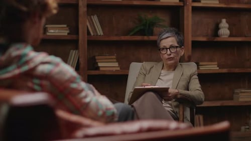 Woman Speaking in Therapy Session with Notepad