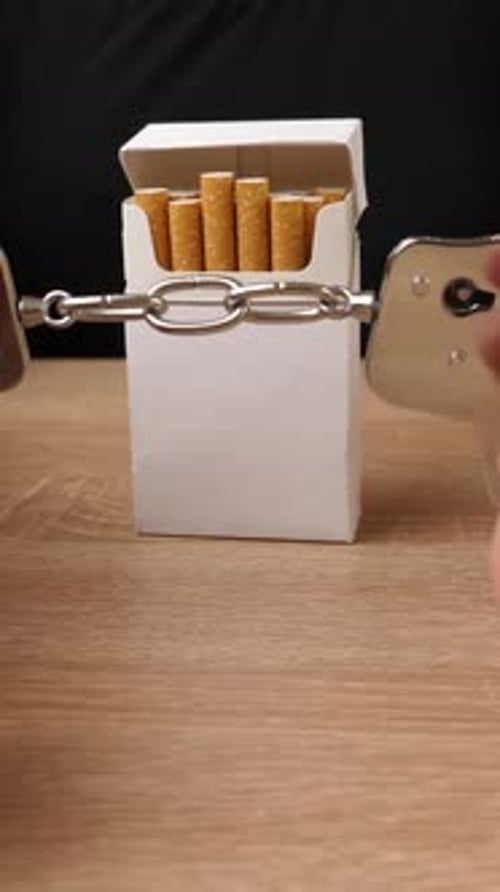 04v. Une femme est menottée à un paquet de cigarettes. Concept de dépendance au tabac. C'est dommage de fumer