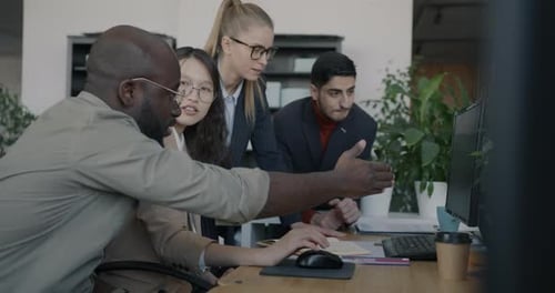 Creative Business Team Talking Pointing at Computer Screen Discussing Company Development in Office