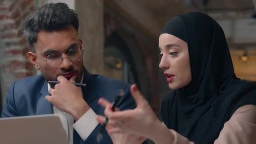 Colleagues collaborate on laptop in modern office