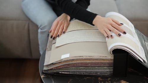Woman Examining Fabric Samples on Table Indoors