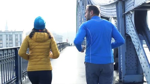 Couple jogging on city bridge in super slow motion at 240fps