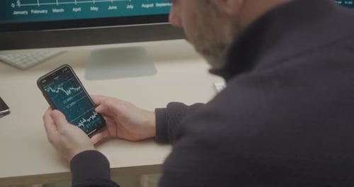 Man Analyzing Financial Data On Smartphone