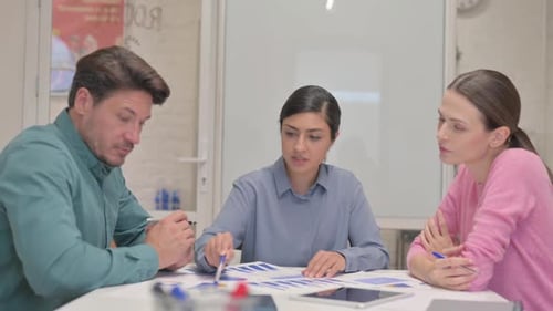 Team Collaborating on Data Charts in Office