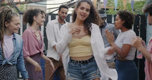 Slow Motion Portrait of Beautiful Young Woman Dancing Outdoors at Street Party with Diverse Group of