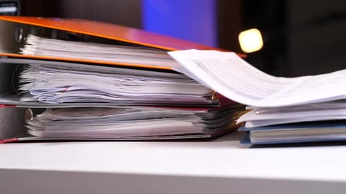 Overstuffed Binders and Documents on a White Desk