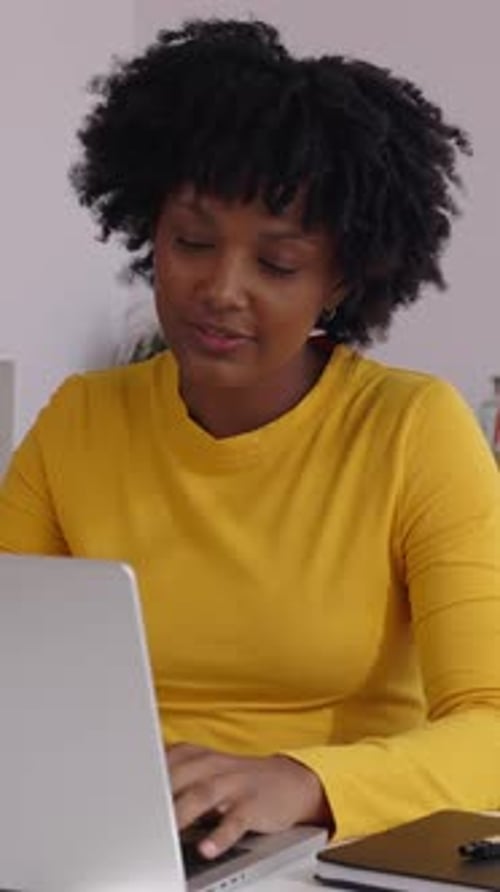Woman Using Laptop and Notebook at Desk