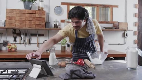 Man Baking at Home with Tablet Recipe