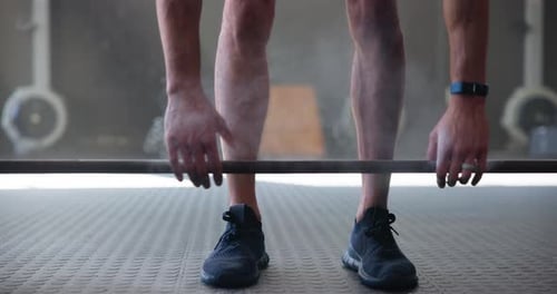 Person, barbell and deadlift in gym for fitness, training and health with body strength benefits