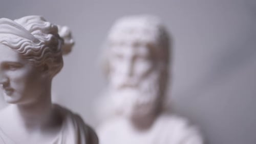 Statue de la déesse grecque Artémis avec d'autres personnages flous, de droite à gauche