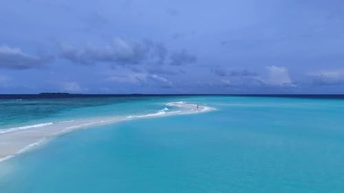 A girl walking on a sandbar in the ocean