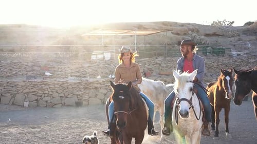 Young Couple Horseback Riding in Sunset Ranch