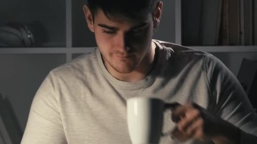 Young Adult Working Late at Laptop with Coffee