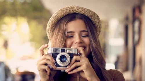 4K video footage of a beautiful young woman taking photographs on a camera in the city