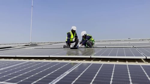 Technician installing solar cell. Installation and maintenance of solar cells on rooftop.