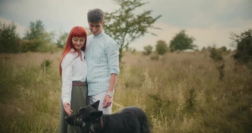 Loving Couple with German Shepherd in Autumn Meadow