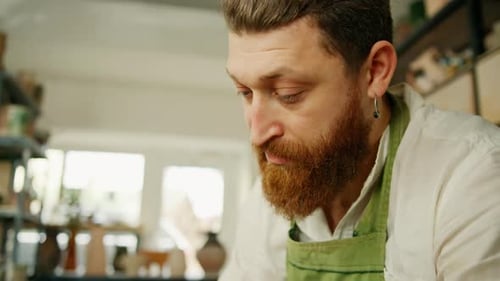 Atelier de poterie : un potier travaille avec un tour de potier, un produit en argile conduit par un potier.