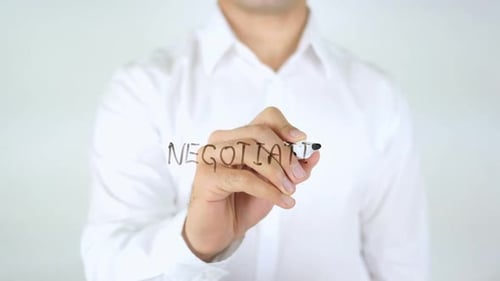 Hand Writes the Word Negotiation with Marker